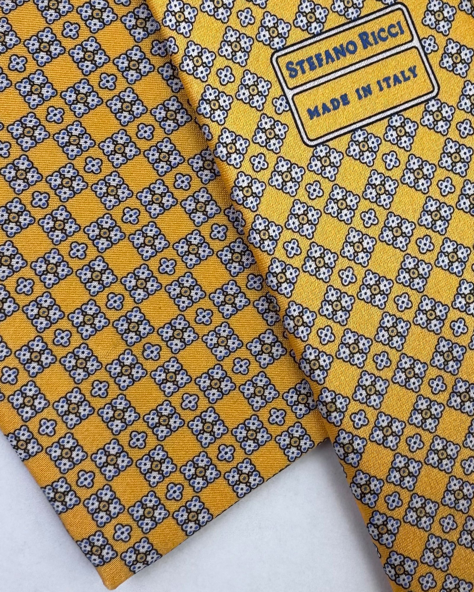 Patterned tie with yellow and gray checkered design on a white background

